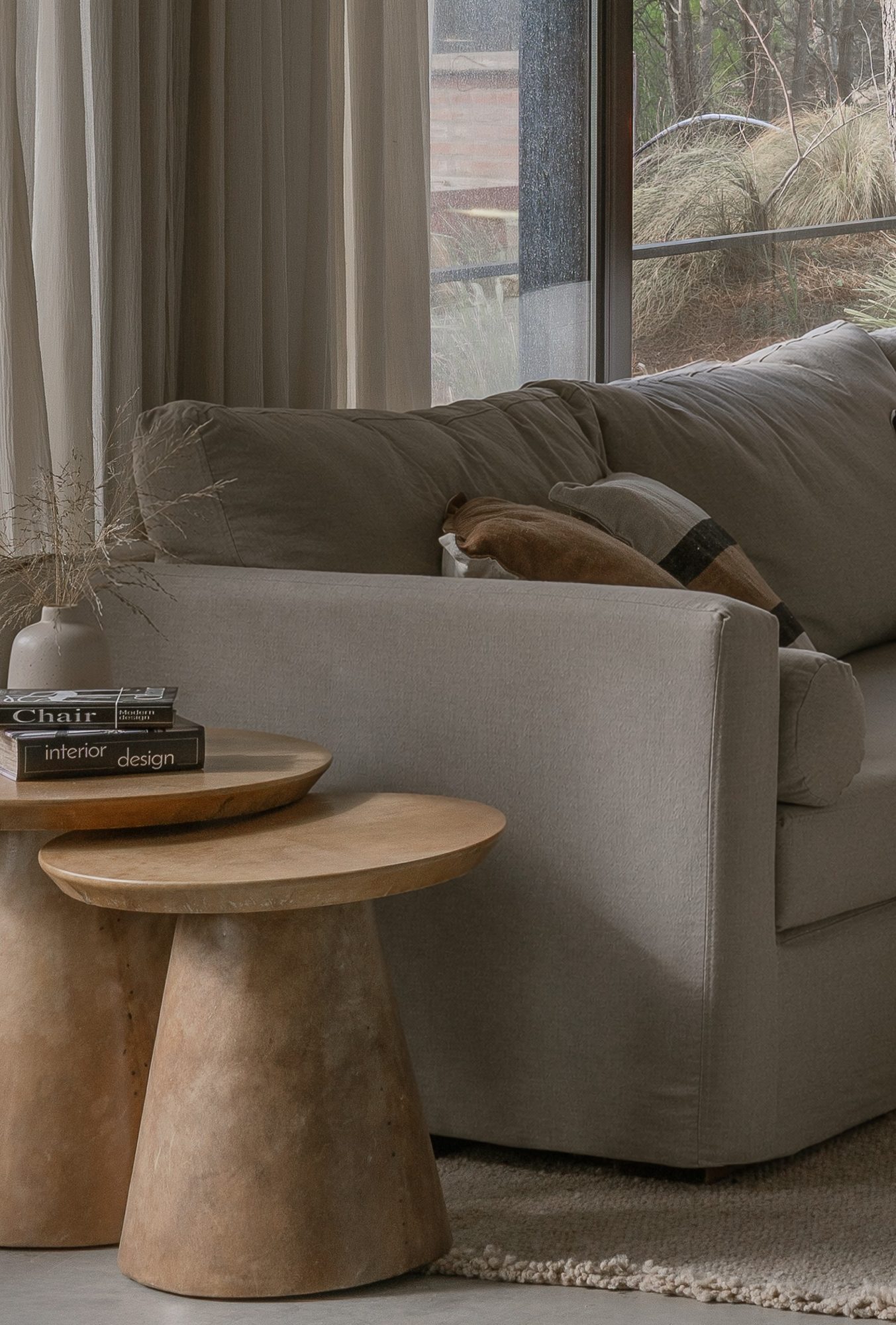 Detalle del living: mesas auxiliares de madera torneada junto al sofá — CORNER Arquitectura