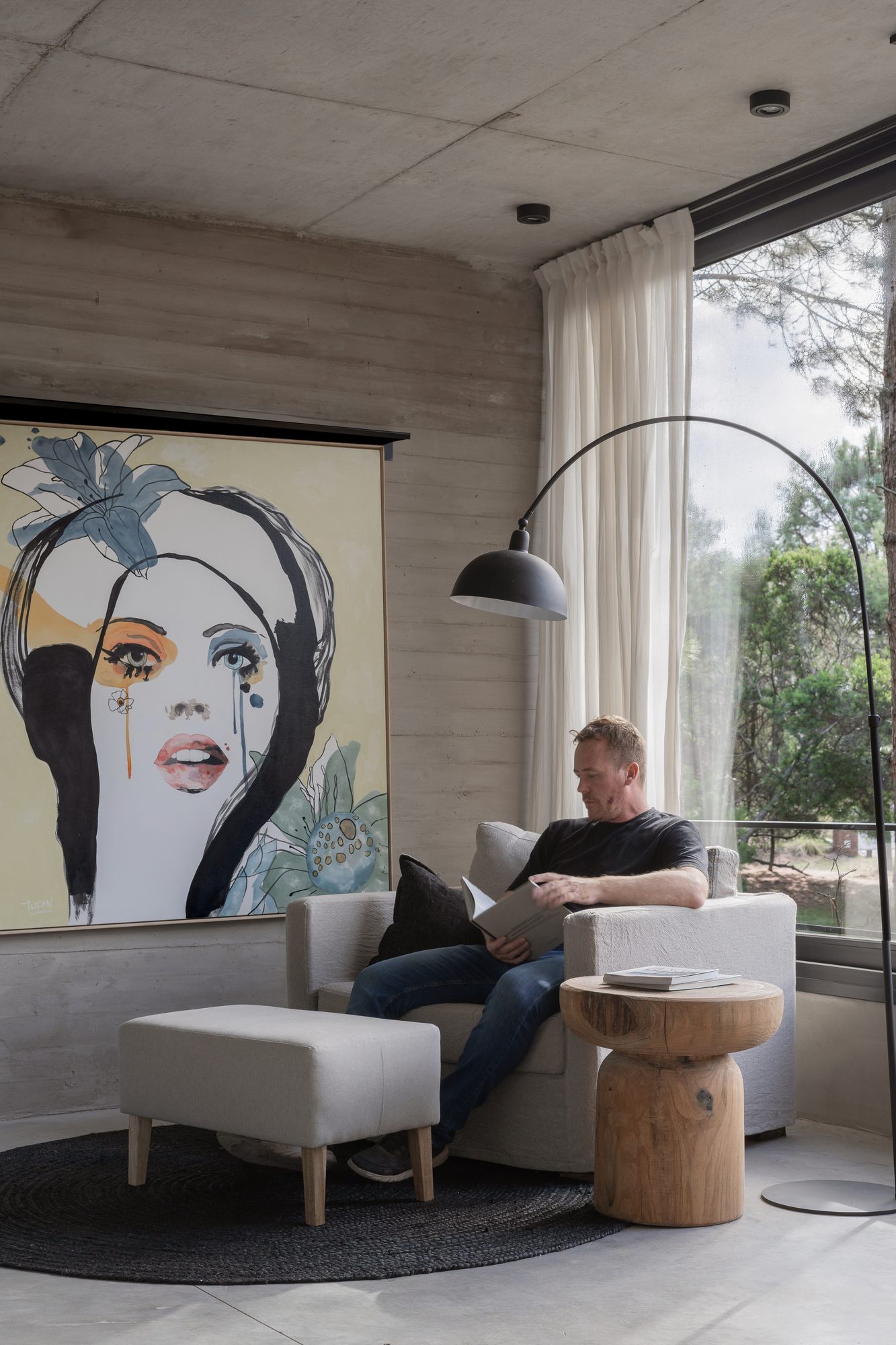 Estar con cuadro de gran formato, lámpara de arco y sillón junto al ventanal — CORNER Arquitectura