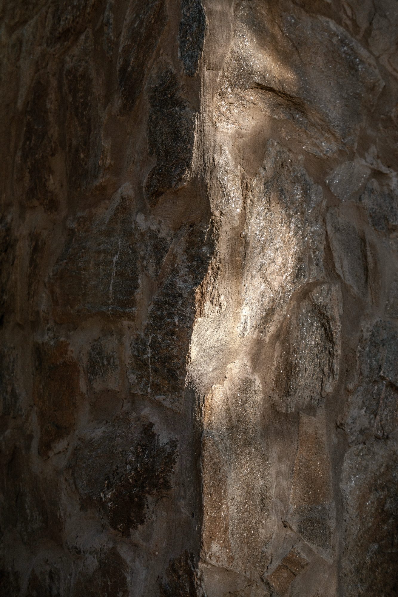 Detalle de muro de piedra natural con luz lateral — CORNER Arquitectura