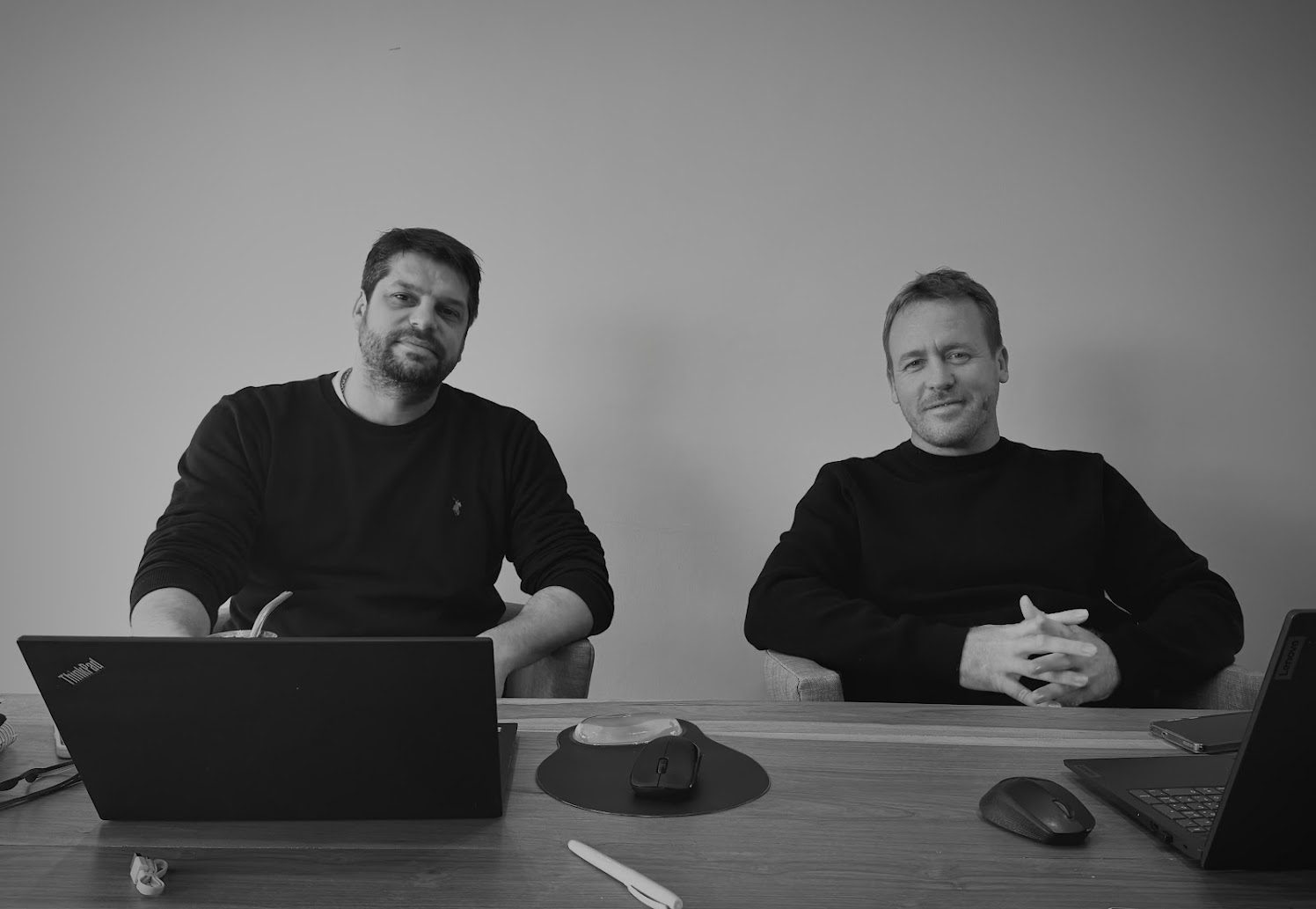 Dos integrantes del equipo trabajando en la mesa del estudio — CORNER Arquitectura