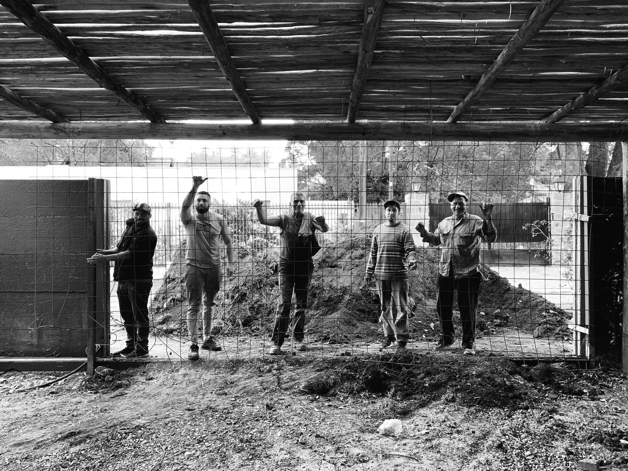 El equipo de obra celebrando sobre el terreno, bajo una pérgola de cañas — CORNER Arquitectura