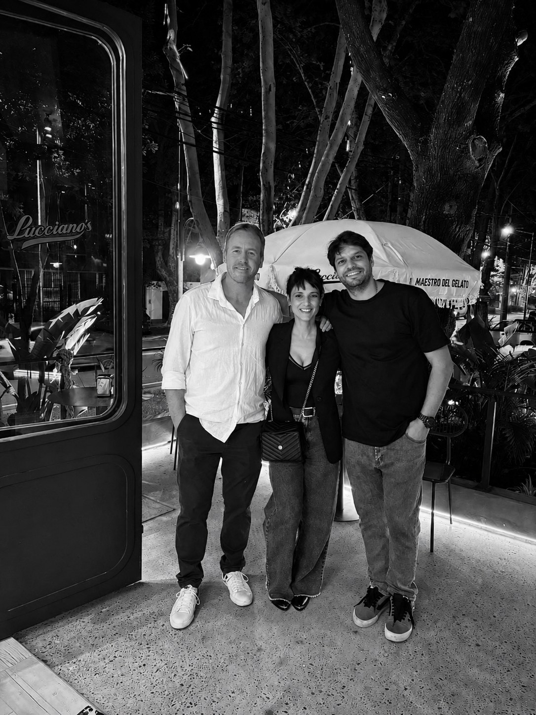 El equipo frente al local de Lucciano's terminado, de noche — CORNER Arquitectura